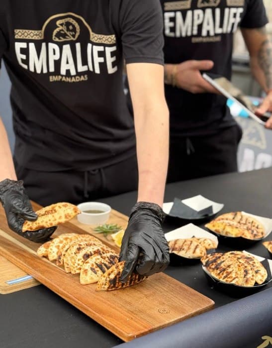 Empalife team serving fresh-baked empanadas